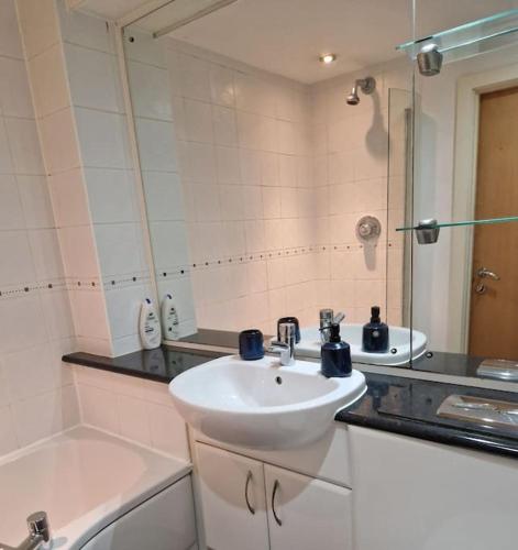 een badkamer met een wastafel en een spiegel bij Salford Quays Apartment, perfect location in Manchester