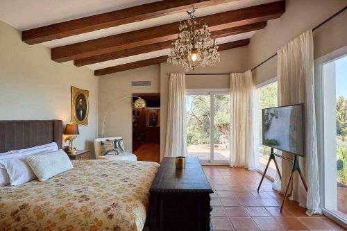 a bedroom with a large bed and a chandelier at Villa en Calonge con Gran piscina in Calonge