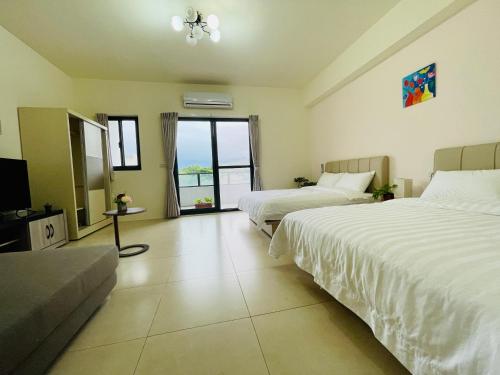a hotel room with two beds and a television at Jiu Xingji in Dayin