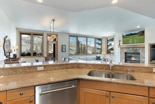 a large kitchen with two sinks and a fireplace at Beaver Creek Highlands Lodge 209 in Beaver Creek