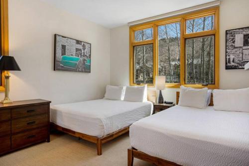 duas camas num quarto com duas janelas em Beaver Creek Highlands Lodge 209 em Beaver Creek