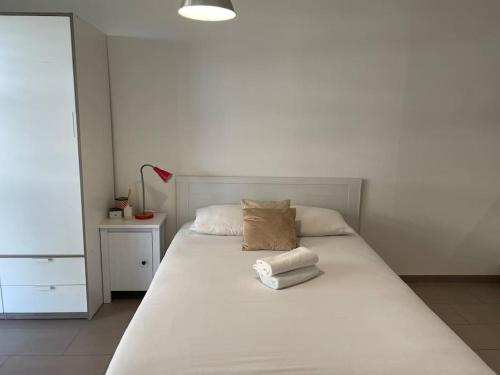 ein Schlafzimmer mit einem weißen Bett mit zwei Handtüchern darauf in der Unterkunft Joli studio confortable ! in Prilly