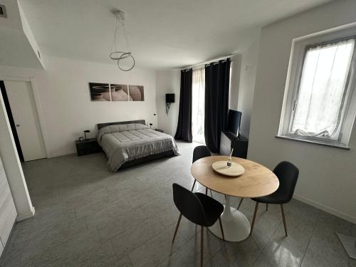 a bedroom with a bed and a table and chairs at ] DOMA [ in Inveruno