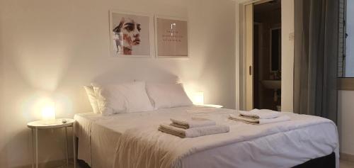 a bedroom with a white bed with towels on it at BLUE LUXURY APARTMENT (BREAKBOOKING CY-SERVICES LTD) in Limassol
