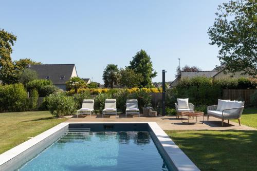 une cour avec une piscine et des chaises longues dans l'établissement Gîte La grange 4 étoiles, cosy & chic près Vitré, Rennes, Mont St Michel, à Val-dʼIzé