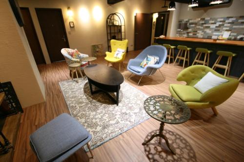 a living room with chairs and tables and a bar at NK Hostel in Taipei