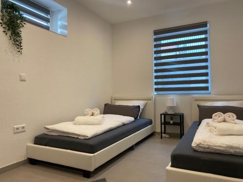 2 Betten in einem Zimmer mit Fenster in der Unterkunft Apartment Business Suite mit Netflix Premium & Parkplatz, zentral zu Audi & Schwarz Gruppe with 2 Bedrooms & Fußbodenheizung in Bad Friedrichshall