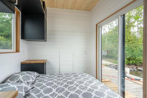 una camera con un letto e una grande finestra di Allure Muskoka Houseboat a Huntsville