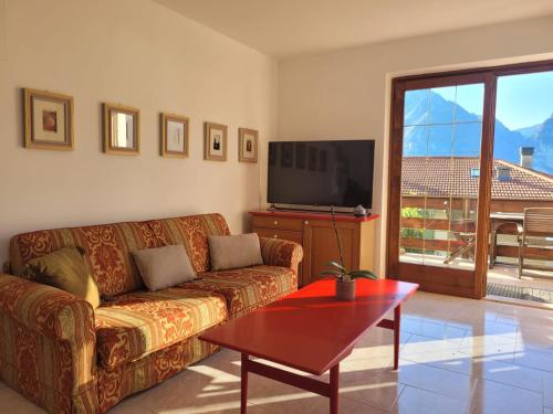 a living room with a couch and a flat screen tv at Appartamento Marocche in Nago-Torbole