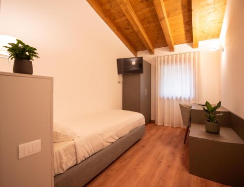 a bedroom with a bed and a desk and a television at Agri-alloggio le Poscole Al Canton in Castelgomberto