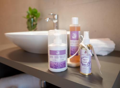 a counter with three bottles of soap and a sink at Agri-alloggio le Poscole Al Canton in Castelgomberto