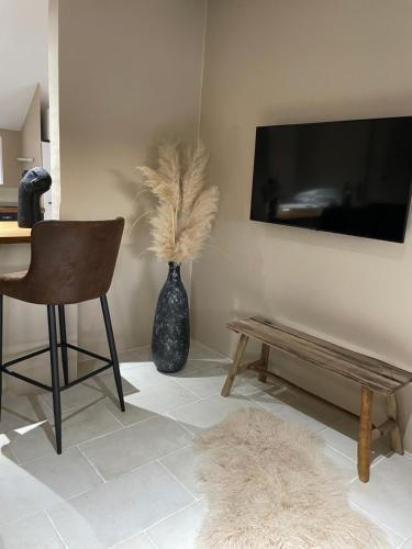 a living room with a table and a vase with feathers at Maison Les Roches Cadre unique in Rochefort-sur-Nenon