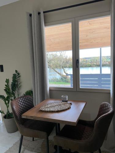 a table and chairs in a room with a window at Maison Les Roches Cadre unique in Rochefort-sur-Nenon