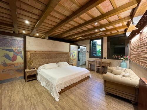 sypialnia z dużym łóżkiem i kanapą w obiekcie Hotel Històric w mieście Girona