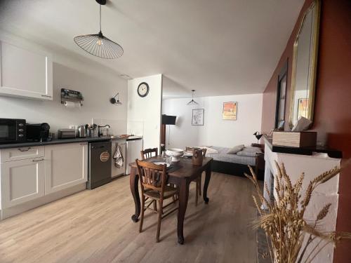 a kitchen and a living room with a table in a room at L’Etape, cœur de ville in La Charité-sur-Loire