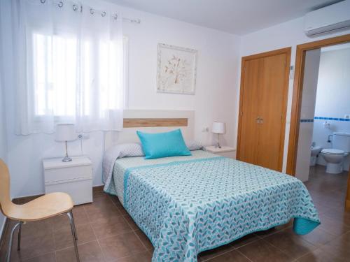 Schlafzimmer mit einem Bett mit blauer Decke in der Unterkunft Chalet con piscina solo para familias in Conil de la Frontera