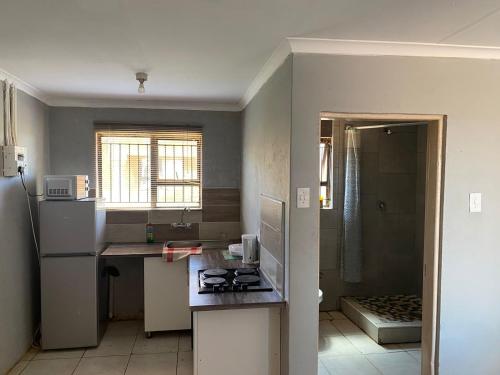 a small kitchen with a counter and a refrigerator at AIRPORTVIEW HEIGHTS 