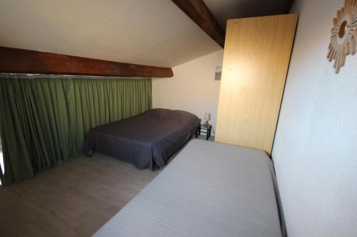- une chambre avec 2 lits et un rideau vert dans l'établissement Maison de vacances, 4 à 5 couchages, cuisine séjour climatisé dans résidence avec piscine, les Jardins de Portiragnes, 500m de la mer, LRJP31, à Portiragnes