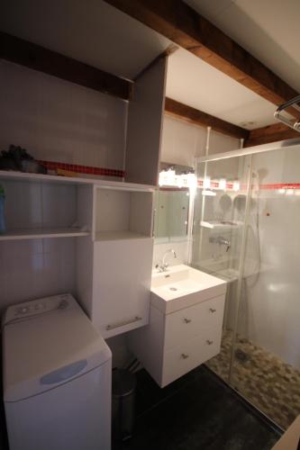 une salle de bain blanche avec un lavabo et une douche dans l'établissement Maison de vacances, 4 à 5 couchages, cuisine séjour climatisé dans résidence avec piscine, les Jardins de Portiragnes, 500m de la mer, LRJP31, à Portiragnes