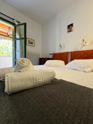 a bedroom with two beds and a large window at Muntenia Inn Apartments and Suites in Kalavrita