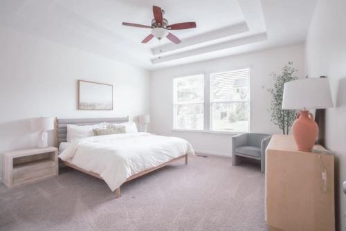 - une chambre blanche avec un lit et un ventilateur de plafond dans l'établissement Modern, Loveland Luxury Oasis by Trails, I-71, à Loveland
