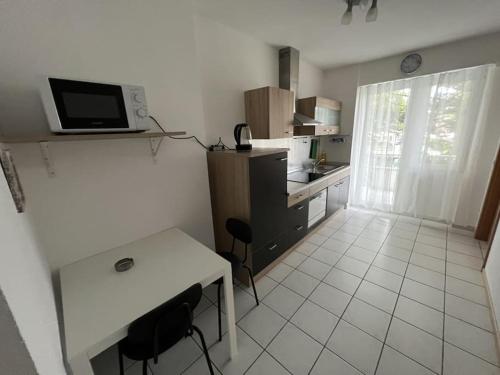 a small kitchen with a table and a microwave at Schöne Apartments am Wasserturm Mönchengladbach MG33 und MG34 in Mönchengladbach