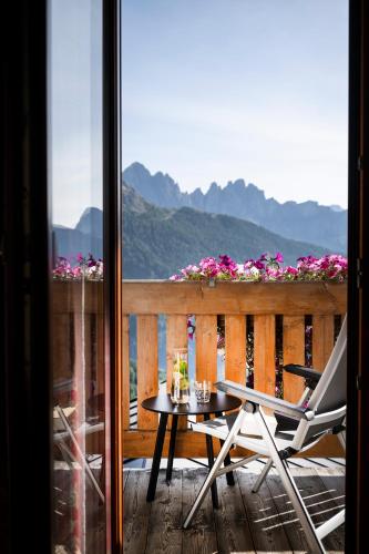 a table and a chair on a balcony with a view at Berghotel Schlemmer in Bressanone