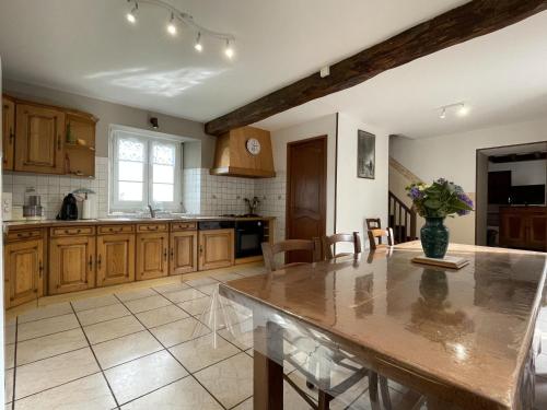 - une cuisine avec des placards en bois et un vase de fleurs dans l'établissement Chez bonnemasou, à Bescat