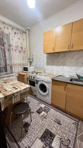 kuchnia z pralką i zlewem w obiekcie Чистая и уютная квартира в 6-ом микрорайоне w mieście Taraz