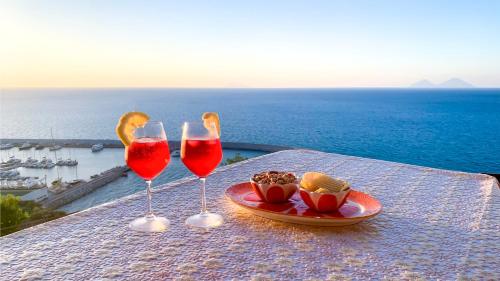カーポ・ドルランドにあるPerla d'Orlandoの海の景色を望むテーブルの上にグラスワイン2杯