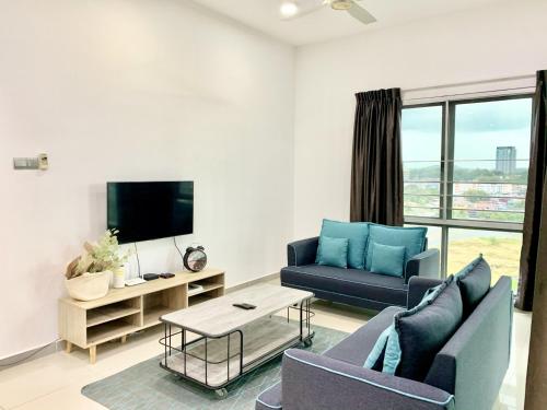 a living room with two blue couches and a tv at Deco Home @ Imago The Loft in Kota Kinabalu