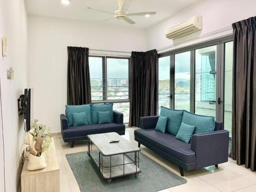 a living room with two blue couches and a table at Deco Home @ Imago The Loft in Kota Kinabalu