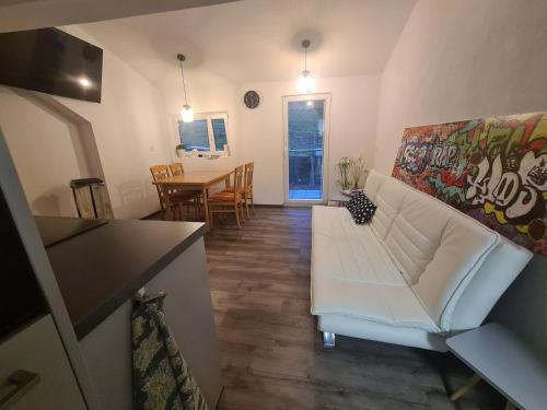 a living room with a white couch and a table at Wohnung mit 2 Schlafzimmern in Wutöschingen