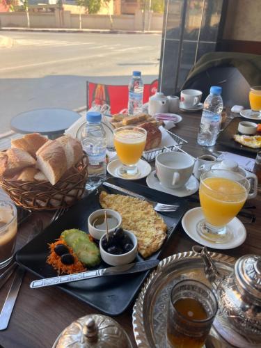 einen Tisch mit Teller mit Lebensmitteln und Gläsern Orangensaft in der Unterkunft Appartement Wynwood 2 in Oujda