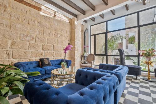 a living room with blue couches and a brick wall at Ca Sana Teulada Moraira, Grupo Terra de Mar, alojamientos con encanto in Moraira