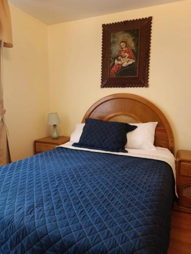 a bedroom with a blue bed and a painting on the wall at Departamento zona exclusiva Cayma Arequipa in Cayma