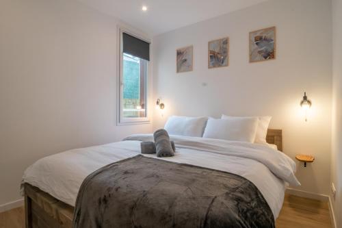 une chambre avec un grand lit avec des draps blancs dans l'établissement F2 hypercentre - Proche gare - WIFI gratuite, au Havre