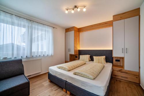 1 dormitorio con cama, sofá y ventana en Ferienwohnung Pfelders, en Pfelders