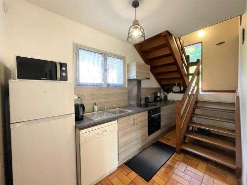 une petite cuisine avec un réfrigérateur et un évier dans l'établissement Chalet 2 lalanne, à Béost