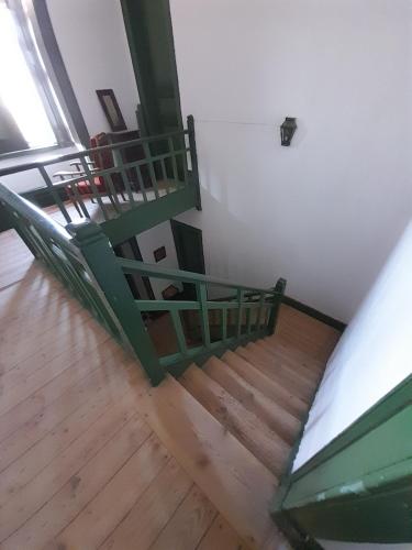a green staircase in a room with wooden floors at Prédio na Amêndoa in Amêndoa