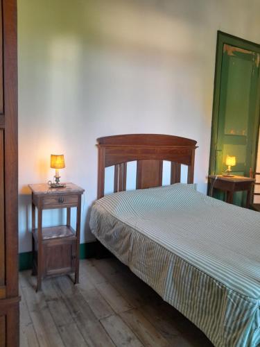 een slaapkamer met een bed en een tafel met een lamp bij Prédio na Amêndoa in Amêndoa