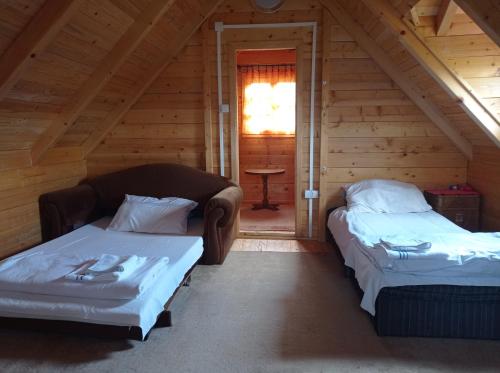 two beds in a log cabin with a window at Vinci brvnara Omladinac in Vinci