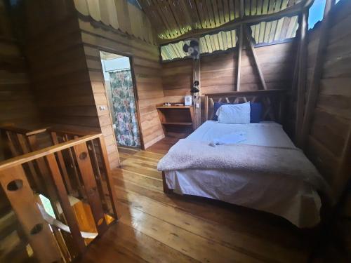 a bedroom with a bed in a wooden cabin at Oski Lodge, Rain Forest Rincón de la Vieja in Upala