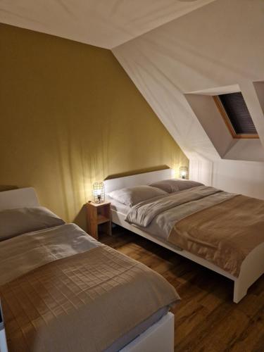 two beds in a bedroom with an attic at Apartmán Eliška Filipovice in Bělá pod Pradědem