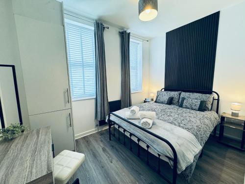 a bedroom with a bed with a black headboard at Spanish City View, Stylish Sea Front Apartment Free Onsite Parking in Whitley Bay