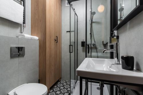 La salle de bains est pourvue d'un lavabo, de toilettes et d'une douche. dans l'établissement Klimczok Apartamenty, à Bystra