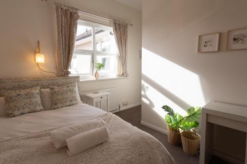 Schlafzimmer mit einem weißen Bett und einem Fenster in der Unterkunft Harry's House Poole in Poole