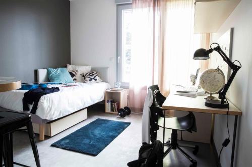 1 dormitorio con cama, escritorio y ventana en Résidence Kley Angers Centre en Angers