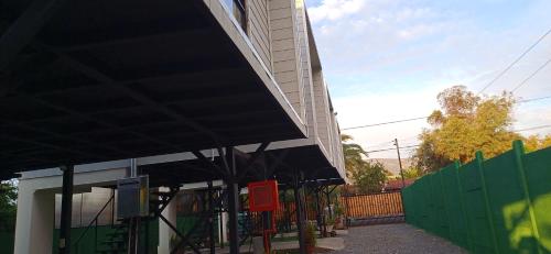 a building with a black awning next to a fence at Loftdonalejandro in Machalí