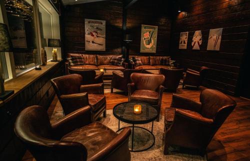a bar with leather chairs and couches and a table at Eriks Villa in Funäsdalen